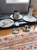 Group view of all pewter items and glass decanter on floor