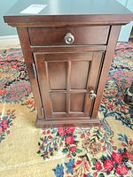 Front view showing drawer, paneled door, hardware