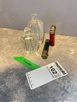 Two cut crystal perfume bottles with stoppers and two coloured glass scent vials displayed on countertop