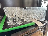 Group of Waterford stemware and tumblers on cabinet shelf