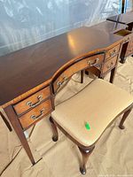Full view of wood vanity with stool underneath