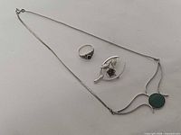 Necklace, ring and brooch laid out