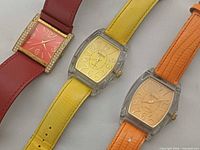 Front view of all three watches showing dial designs and strap colors