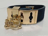 Bracelet fastened showing buckle, chain and BCBGMAXAZRIA logo