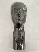 Front view of glossy black mannequin head with elongated neck