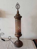 Lamp illuminated showing lattice pattern and cord with switch