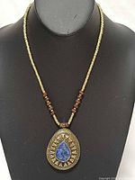 Full necklace on display bust showing bead arrangement and pendant