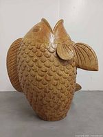 Front view of terracotta koi fish showing scales and open mouth