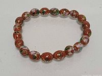 Full view of red cloisonné bead bracelet in circular form