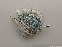 Front view of brooch showing rhinestone layout and metal texture