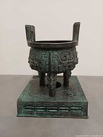 Front view of bronze ding on stand