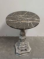 Full view of table showing round marble top and pedestal base