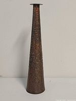 Full frontal view of tall tapered bronze vase