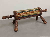 oblique view showing full footstool, fabric, legs and one handle