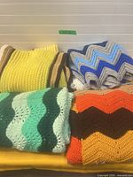 All four folded afghans showing colour patterns