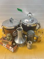 Group shot of entire lot showing both ice buckets, carafe, steins, mug, shot glass, frog, plaque and corkscrew