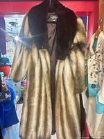 Front view of long faux fur coat showing collar, pattern and lining