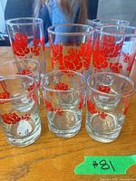 Front view showing four tall, one medium and three small glasses with red rose pattern