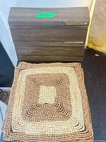 Top view of brown metal storage container with labels and stack of place mats