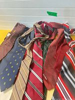 All 11 neckties spread out displaying patterns, colours and visible Pierre Cardin branding