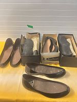 Three pairs of black galoshes with boxes displayed together