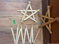 Three wooden folding rulers arranged in star and W shapes