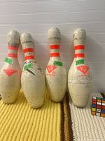 Front view of all four bowling pins showing logos and wear