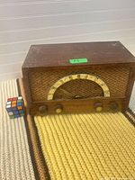 Front view of wooden radio with knobs, dial and speaker grille