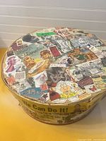 Top view of round wooden box lid showing full decoupage collage