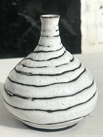 Front view of the bulbous weed vase with speckled glaze and dark stripes