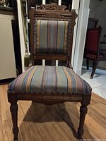 Front view of carved Eastlake chair with striped upholstery