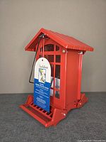 Front view of red Audubon Chateau feeder with tag