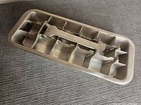 Top view of stainless steel ice cube tray showing lever mechanism and 18 cube compartments