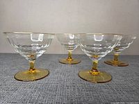 Group shot of all four coupes showing bowl pattern, gold rim, amber stems and bases