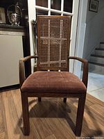 Front view of chair showing wood frame, cane back, fabric seat