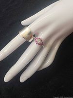 Cluster ring and wide concave band on mannequin hand