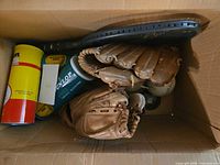 Box containing gloves, tennis ball cans, racquet