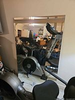 Full view of frameless rectangular mirror leaning against wall