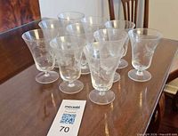 Full group of 10 etched cordial glasses on table