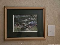 Front view of framed signed giclée water-lily print in light wood frame with green mat