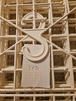 Front view of white plastic grid organizer showing integrated hanger and lattice slots