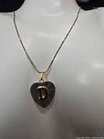 Necklace displayed on bust showing heart pendant with letter D