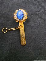 Front view showing cabochon, filigree bezel, chain, engraved bar