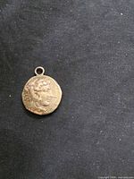 Obverse of coin pendant showing profile head and loop