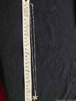 Full length of necklace beside ruler showing length