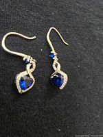 Full view of both earrings showing design and stones