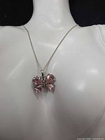 Necklace on bust showing butterfly pendant detail and chain