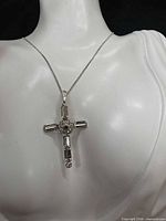 Cross pendant necklace displayed on mannequin torso