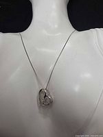 Necklace displayed on bust showing heart pendant and chain