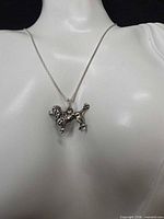 Necklace on bust displaying poodle pendant and chain style